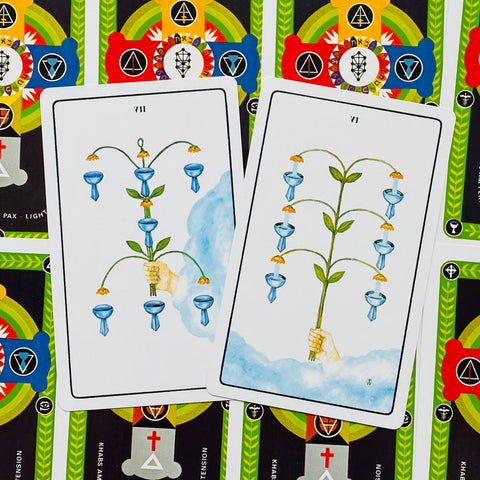 Tarot kortos taurės 7 ir 6, akvarelinis motyvas su ranka laikančia stiebus, iš viršaus ant spalvoto nugarėlių rašto