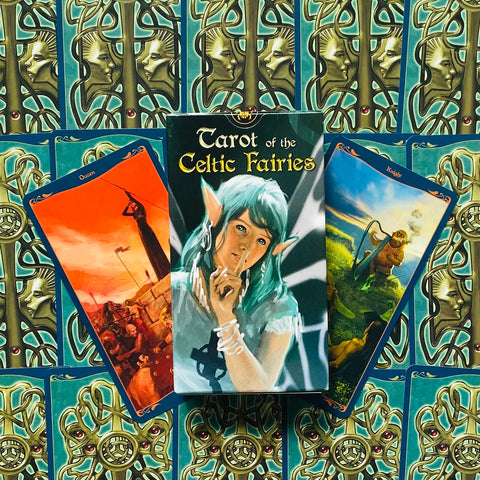 Tarot kortos Celtic Fairies dėžutė centre su dviem atverčiomis kortomis ir žaliais ornamentiniais nugarėliais