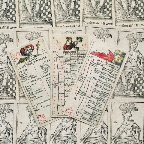 Senovinės kortos, ranka kolorėtos istorinio stiliaus, trys atvertos kortos parodytos iš arti ant iliustruoto fono, akcentuojant tekstus ir ornamentus