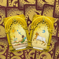 Tarot kortos su auksinėmis arkos rėmelėmis, atviros dvi kortos — The Hanged Man ir Fortitude, bordo nugarėlė