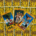 Tarot kortos — trys atvertos taurų rūšies kortos su auksiniu rėmu ant geltonos ornamentuotos nugarėlės, detalus priekis