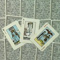 tarot kortos su klasikiniais paveikslais – Ace of Swords, King of Swords ir Two of Cups atverstos ant ornamentuoto nugarėlių fono