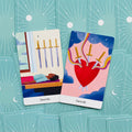 tarot kortos Swords komplektas: dvi atviros kortos (4 ir 3 kardai) ant mėtų nugarėlių fono, matomas priekis ir nugarėlė