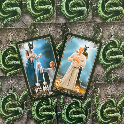 Tarot kortos su tamsiais kraštais, dvi kortos (Devyni taurės ir Aštuoni taurės) ant žalių tentaklių nugarėlių