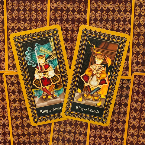 Tarot kortos, atverstos dvi kortos – King of Swords ir King of Wands, sėdinčios ant geltonai-raudono raštuoto nugarėlių fono