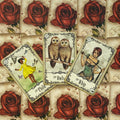 Tarot kortos su raudonų rožių nugara, trys atidengtos kortos (Vaikas, Pelėdos, Vytis) demonstruoja pakuotės dizainą.