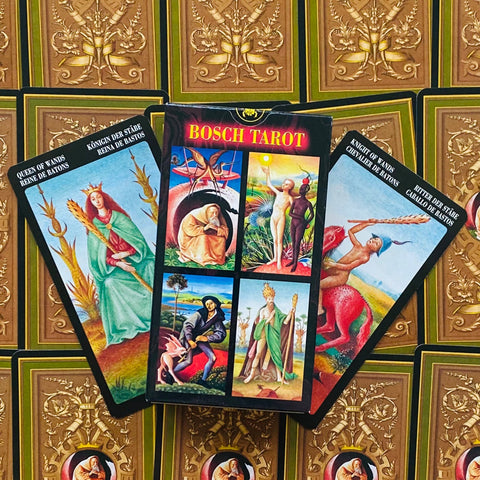Tarot kortos Bosch: ryški dėžutė centre ir trys išskleistos kortos šone, matomi Karalienės ir Riterio piešiniai