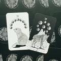 Tarot kortos su gyvūnų iliustracijomis — du atversti variantai (IX katė su žalia akimi ir VIII vilkas su jin‑jang ženklais)