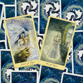 Tarot kortos su mėlynomis nugarėlėmis ir dviem auksuotais, iliustruotais korteliais (Septynios taurės, Šešios taurės) ant išskleistos fono kompozicijos