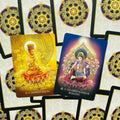 Tarot kortos su auksinėmis ir violetinėmis Budos iliustracijomis, parodytos dvi atverstos kortos su unikalia nugarėle