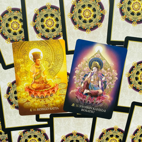 Tarot kortos su auksinėmis ir violetinėmis Budos iliustracijomis, parodytos dvi atverstos kortos su unikalia nugarėle