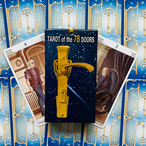 Tarot kortos "Tarot of the 78 Doors" mėlyname dėkle su auksine rankena, išskleistomis nugarėlėmis ir dviem atsivertusiomis kardų kortomis