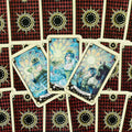 Tarot kortos trys atverstos taurų rūšies kortos (Queen, King, Knight of Cups) ant raudono rombų nugarėlių fono