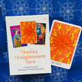tarot kortos Journey to Enlightenment baltame dėkle su atversta ryškiai oranžine 19‑ąja Saulė korta dešinėje, detalus alchemiškas menas