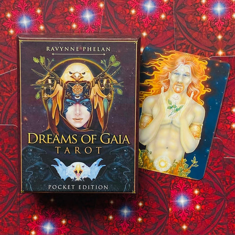 Dreams of Gaia taro kortos, kišeninė dėžutė šalia atverstos saulės figūros kortos ant raudono ornamentinio fono