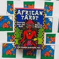 African Tarot spalvota dėžutė (U.S. Games Systems) matoma iš priekio virš fanuotų kortų nugarėlių, ryškus artimas kampas
