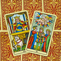 Tarot kortos Marseilio rinkinys, dvi arkos – VII Karieta ir VI Mylimieji, ryškūs spalvoti priekiai ant raudono‑geltono ornamentinio fono