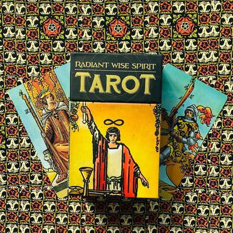 Tarot kortos Radiant Wise Spirit komplektas su geltonu Magas kortos priekiu, trys kortos išfanuotos ant raštuoto fono