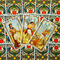 Tarot kortos su egiptietišku nugarėlių raštu, trys atverstos Lazdų kortos (9 ir 10) centre ant spalvoto fono
