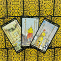 Tarot kortos Rider–Waite komplektas, trys Lazdų rūšies kortos išskleistos ant auksinių ornamentuotų nugarėlių