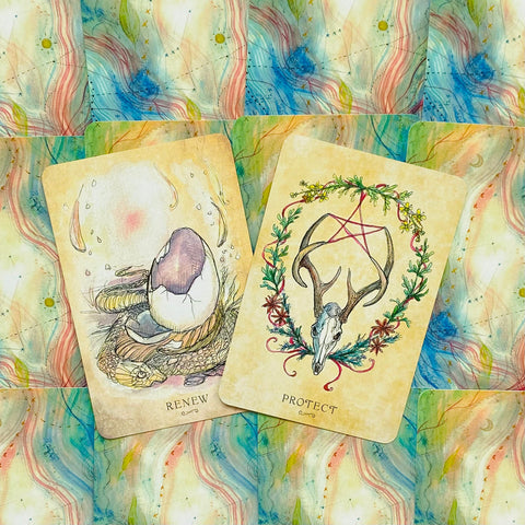 Tarot kortos, dvi atverstos pastelinės kortos Renew ir Protect su elnio kaukole ir perinčiu kiaušiniu ant akvarelinio fono