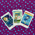 Tarot kortelės — trys taurų rūšies rūmų kortos (karalienė, riteris, berniukas) fanuotos ant violeto žvaigždėto fono