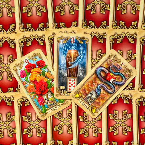 Lenormand kortos su raudonu auksiniu nugarėlių raštu, trijų kortų išdėstymas: Puokštė, Karstas ir Gyvatė, detalus priekinis planas