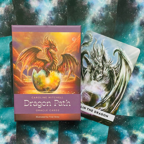 Dragon Path orakulo kortos, violetinė dėžutė su auksiniu drakonu ir šalia atversta sidabrinė korta, matomas dėžutės priekis ir kortos variantas