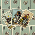 Tarot kortos Rider–Waite stiliaus rinkinyje trys atvertos taurų kortos (Riteris, Karalienė, Karalius) ant mėtų nugarėlių