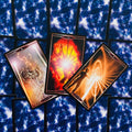 Tarot kortos trijų kortų išklotinė – mėlynos žvaigždėtos nugarėlės ir ugniniai, simboliniai priekiai
