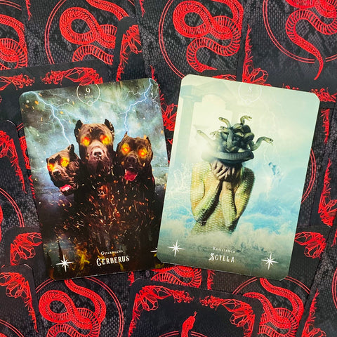 taro kortos: atverstos "Cerberus" ir "Scylla" kortos ant juodų nugarėlių su raudonu gyvačių raštu, detalus dizaino variantas