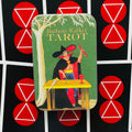 Barbara Walker tarot dėžutė metalinė, žaliu viršeliu su burtininko iliustracija, rodoma iš priekio ant juoda-raudono simbolinio fono