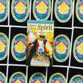Tarot kortos Tarot of the Spirit dėžutė su spalvingu viršeliu, centrinė nuotrauka ant išskleistų kortų nugarėlių fono