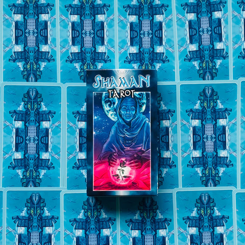 Tarot kortos Shaman su dėžute centre ant simetriškai išdėstytų mėlynų kortų nugarėlių, parodyta komplekte
