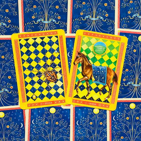 Tarot kortos priekinės kortos voras ir arklys su ryškiais geltonais rėmeliais, detaliomis iliustracijomis ir mėlynu ornamentiniu fonu