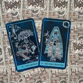 tarot kortos mėlyna versija su The Empress ir The High Priestess atvertos, išryškinančios detalias linijines iliustracijas ir simboliką