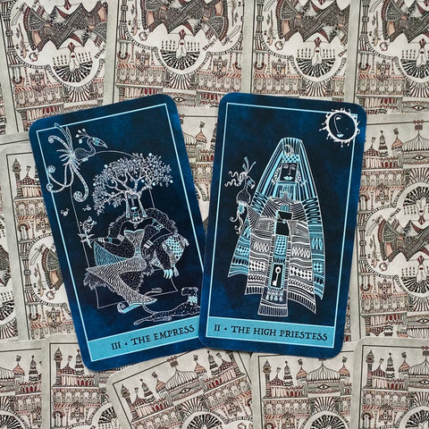 tarot kortos mėlyna versija su The Empress ir The High Priestess atvertos, išryškinančios detalias linijines iliustracijas ir simboliką
