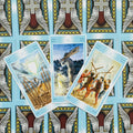 Tarot kortos trijų lazdų (5, 6, 7) išdėstymas su šviesiai mėlynomis nugarėlėmis ir kryžiaus–sparnų raštu