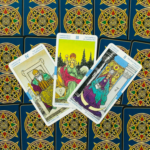 Tarot kortos Rider–Waite stiliumi, trijų kortų (Imperatorius, Imperatorė, Aukštoji kunigė) išdėstymas ryškiai ant mėlynos nugarėlės
