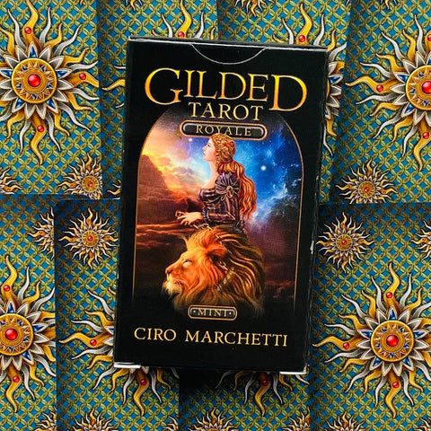 Tarot kortos Gilded Tarot Royale, Ciro Marchetti — juoda priekinė dėžutė ant ornamentuoto mėlyno ir aukso fono