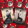 tarot kortos, dvi iliustruotos kortos Haunted ir Grief ant raudonos mėnulio nugarėlės fono