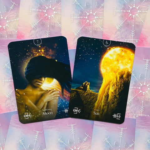Tarot kortos Moon ir Sun rinkinys ant rožinio kosminio fono, ryškus mėnulio tamsos ir saulės šviesos kontrastas
