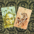 tarot kortos Hush Tarot komplektas su dviem atverstomis kortomis — žalsvas veidas su kačiukais ir rožinė raitelė ant vienaragio