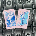 tarot kortos rožiniu kraštu — anime stiliaus Major Arcana „The Magician“ ir „The Fool“ išdėstytos ant juodo raštuoto fono