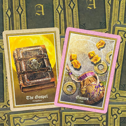 Tarot kortos su dviem atverstomis kortomis: The Gospel su geltonu mėnuliu ir Games su rožiniu rėmeliu ir kauliukais