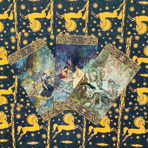 tarot kortos su iliustruotomis pasakų scenomis, trys kortos išdėstytos ventilatoriumi ant tamsiai mėlyno žvaigždėto audinio