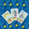 Tarot kortos Rider–Waite, trys taurės (Ten, Page, Knight) išdėstytos trikampiu ant mėlyno žvaigždėto fono, matomos kortų iliustracijos