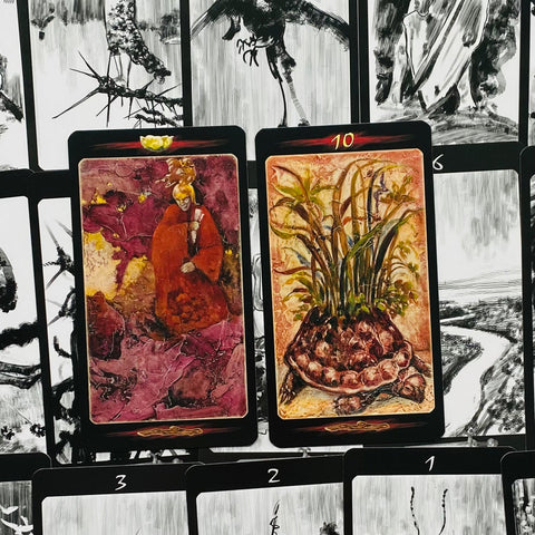 tarot kortos dailiai iliustruotos juodu rėmeliu — kairėje raudona apsiaustu figūra, dešinėje 10 su augalu ir šaknimis