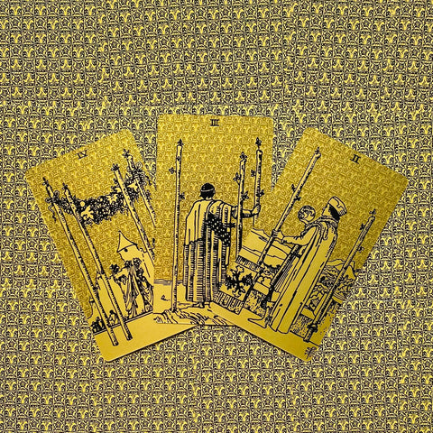 tarot kortos auksiniu leidimu, trys vijos (Three of Wands) išdėstytos ventiliatoriumi ant raštuoto fono, blizgios ir kolekcionieriams