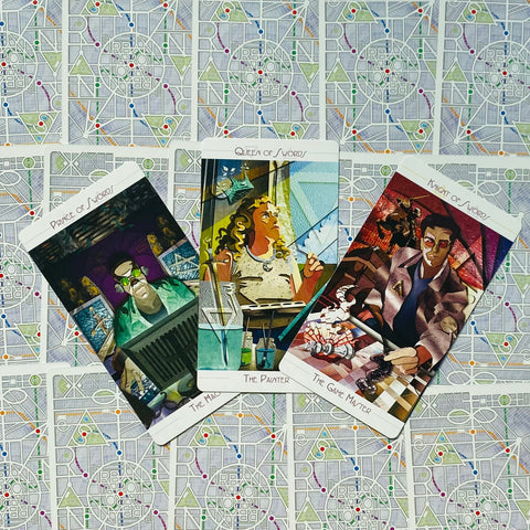 Tarot kortos su spalvingomis iliustracijomis, trys atvertos kortos (Kardų princas, Kardų karalienė, Kardų riteris) ant geometrinio nugarėlių fono